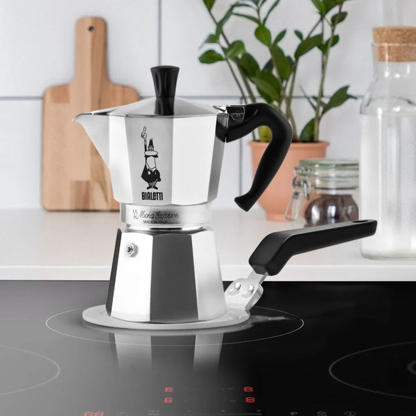 Disque à induction 13 cm pour cafetière italienne - Acier inoxydable - Manche en bakélite noir riveté brochable - Marquage de 3 diamètres de cafetière en aluminium (de 1 à 6 tasses) - Diamètre : 13 cm - Pratique et conçu pour être utilisé avec les cafetières aluminium. En vente chez Arlo’s Coffee, artisan torréfacteur de café de spécialité situé à Rambouillet dans les Yvelines. Café en grain et moulu. Café éthique et responsable.